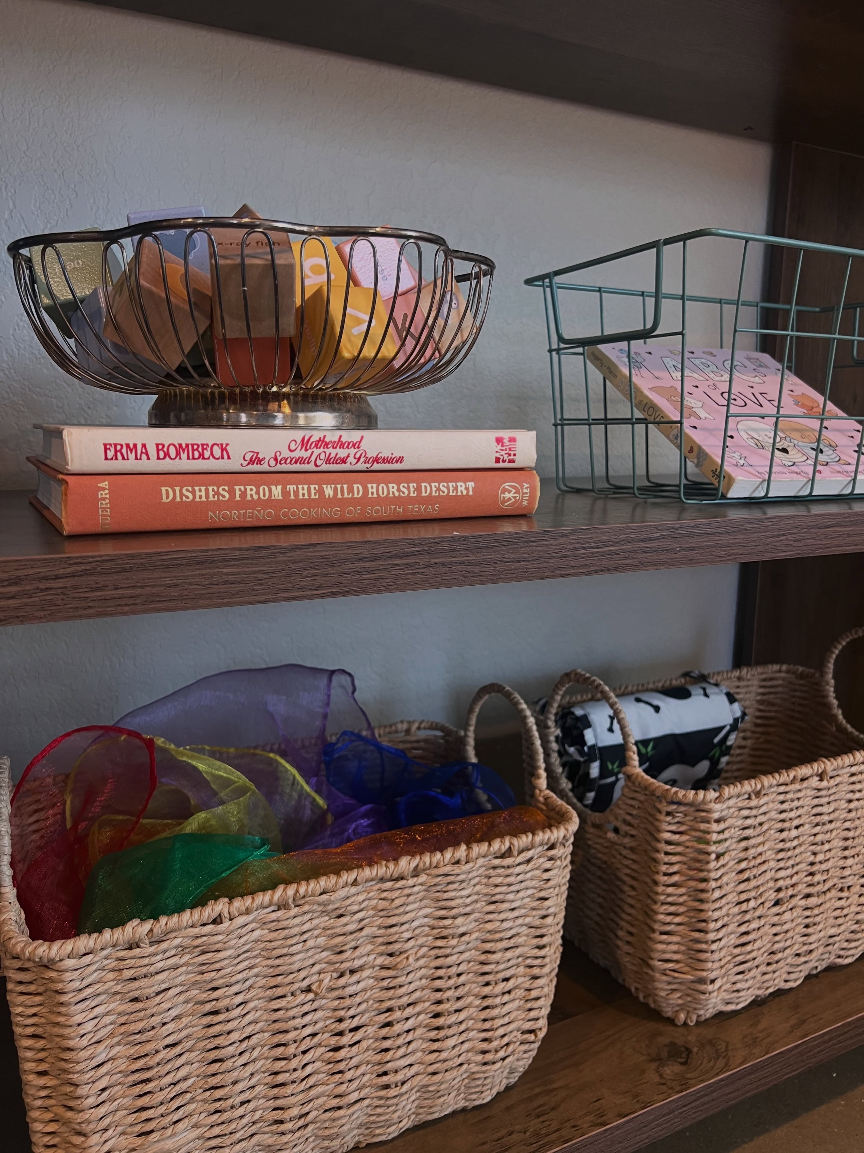 Woven baskets and wire bins organizing play scarves, books, and everyday essentials